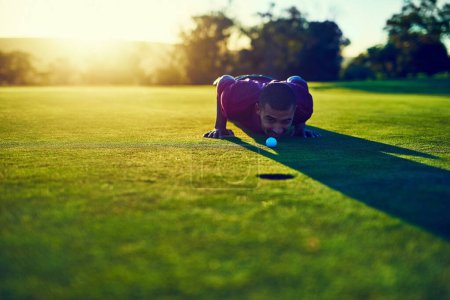 Foto de Presionando. un joven mirando el putt durante una ronda de golf - Imagen libre de derechos