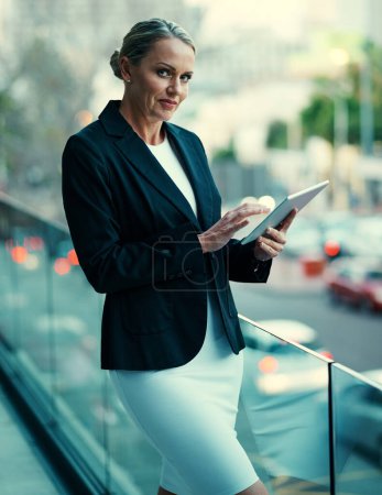 Photo for Staying on top of things with smart technology. Portrait of a mature businesswoman standing outside on the balcony of an office and using a digital tablet - Royalty Free Image