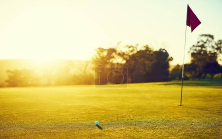 Foto de Hundirlo para ganarlo. una pelota de golf y bandera en un campo vacío - Imagen libre de derechos