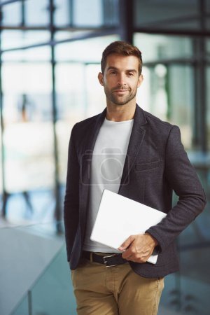 Foto de Siempre estoy trabajando en mejorar mi negocio. un hombre de negocios guapo sosteniendo una tableta digital - Imagen libre de derechos