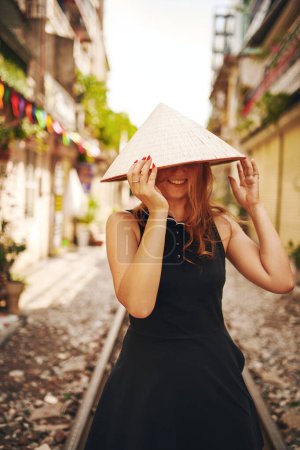 Foto de Estoy viviendo mis sueños de lista de deseos. una joven con un sombrero cónico mientras explora una ciudad extranjera - Imagen libre de derechos