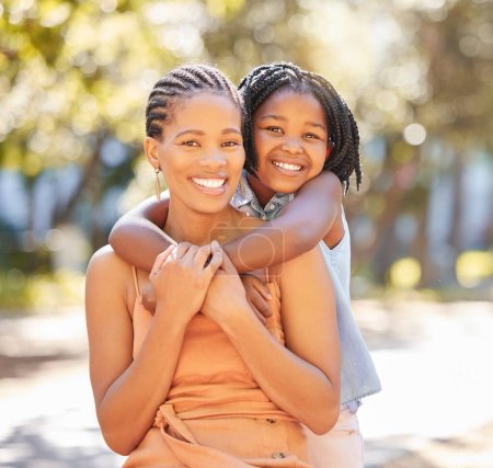 Foto de Abrazo, retrato de madre e hija en el parque relajándose juntos en las vacaciones de verano con sonrisa. Apoyo, niña o mujer negra feliz, mamá y vinculación en abrazo con amor en el jardín en Sudáfrica. - Imagen libre de derechos