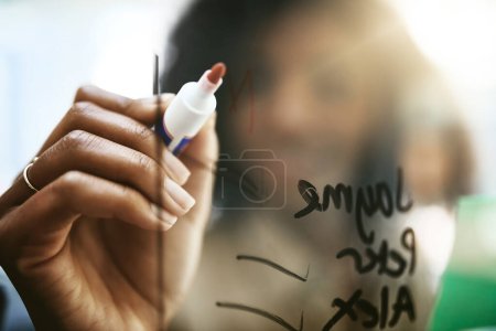 Photo for The strategist is at it again. Closeup shot of a young businesswoman writing notes on a glass screen in an office - Royalty Free Image