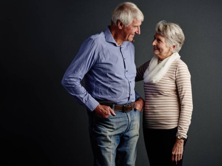 Foto de Mirándole profundamente a los ojos. Estudio de una pareja de ancianos cariñosos posando sobre un fondo gris - Imagen libre de derechos