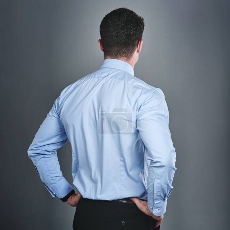 Photo for Let nothing hold you back from moving forward. Rearview studio shot of a young businessman standing against a grey background - Royalty Free Image