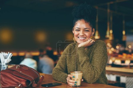 Foto de El café es la comida más importante del día. Retrato de una joven atractiva disfrutando de una taza de café en un café - Imagen libre de derechos