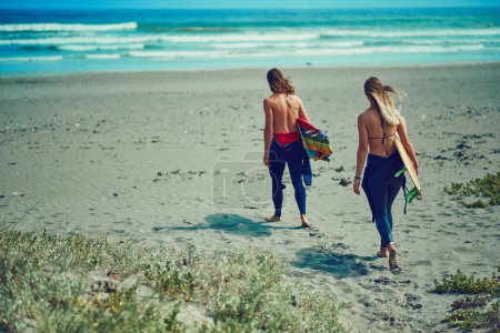 Foto de Al lugar donde el tiempo se detiene. una joven pareja caminando por la playa con sus tablas de surf - Imagen libre de derechos