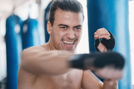 Photo for Sports, boxing and man punch in gym for training, workout and exercise for mma fighting. Fitness, body builder and face of male athlete ready for boxer competition, practice and martial arts match. - Royalty Free Image
