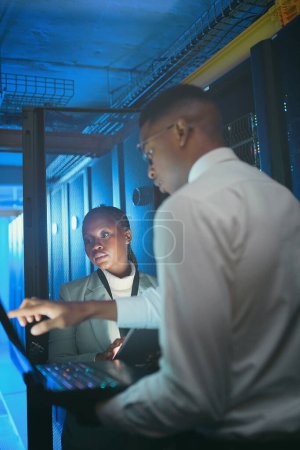 Photo for Were suffering from low download speeds. two young IT specialists standing in the server room and having a discussion while using a technology - Royalty Free Image