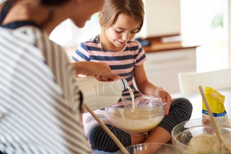 Téléchargez les photos : Mère, cuisinière ou enfant cuisiner dans la cuisine en famille avec un jeune enfant apprenant la recette de cookies à la maison. Pâtisserie à gâteaux, pâtissier au lait ou maman aidant ou enseignant à la fille heureuse à cuisiner pour le développement de l'enfant. - en image libre de droit