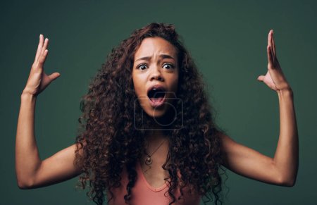 Wow, wtf and portrait of woman mind blown in studio by news, gossip or drama on green background. Omg, face and female model shocked, surprise and confused with open mouth emoji, hands or expression.