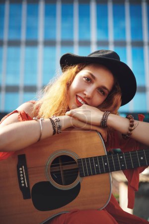 Foto de Mi hogar está donde esté mi guitarra. una hermosa joven en la ciudad con su guitarra - Imagen libre de derechos