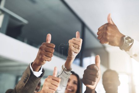 Photo for Well done on yet another win. Closeup shot of a group of businesspeople showing thumbs up in an office - Royalty Free Image