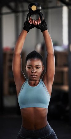 Foto de Fitness, kettlebell o retrato de mujer negra en ejercicio de entrenamiento, entrenamiento o musculación para el agarre. Constructor de cuerpo, poder femenino o atleta deportivo fuerte con en el gimnasio para comenzar a levantar pesas pesadas. - Imagen libre de derechos