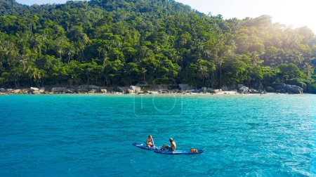 Photo for Something to please the adventurous. a man and woman paddle boarding across the sea - Royalty Free Image