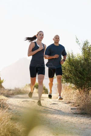 Photo for Morning, fitness and couple trail running as workout or morning exercise for health and wellness together. Sport, man and woman runner run with athlete as training in nature for sports or energy. - Royalty Free Image