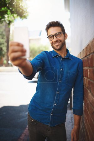 Foto de Un selfie establece el estado de ánimo para el da. un hombre hablando por su celular mientras estaba en la ciudad - Imagen libre de derechos