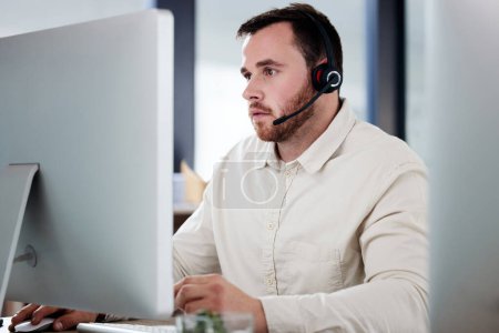 Photo for Customer service, man with a headset and computer at desk of his modern office workplace. Telemarketing or online communication, support or crm and male call center agent at his workstation - Royalty Free Image