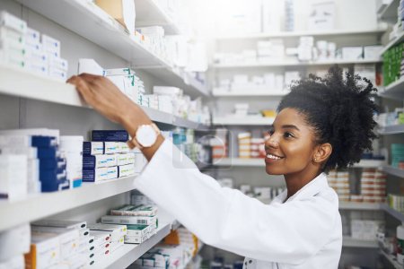 Téléchargez les photos : Voici ce que je cherche. une pharmacienne prenant un produit sur les étagères - en image libre de droit