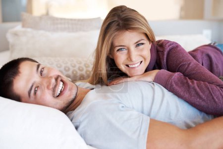 Téléchargez les photos : Profitant de prendre le temps de se détendre ensemble. Jeune couple attrayant couché ensemble à la maison - en image libre de droit
