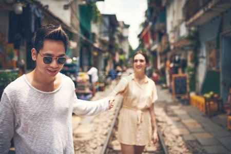 Téléchargez les photos : Partout où vous allez devient une partie de votre histoire. un jeune couple marchant dans les rues du Vietnam - en image libre de droit