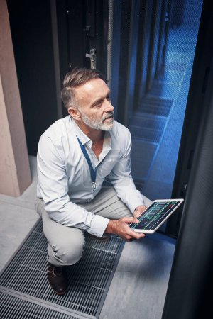 Photo for Get better internet speed with help from this IT guru. a mature man using a digital tablet while working in a server room - Royalty Free Image