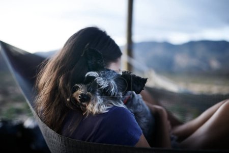 Téléchargez les photos : Les meilleures choses dans la vie sont libres. une jeune femme se relaxant avec son chien adorable dans un hamac - en image libre de droit