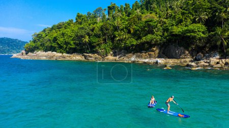 Photo for What better way to spend a summer vacation. a man and woman paddle boarding across the sea - Royalty Free Image