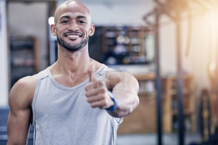 Photo for Thank you, portrait of man and with thumbs up at the gym with a lens flare. Success or motivation, agreement or health wellness and male athlete happy for support workout or fitness training. - Royalty Free Image