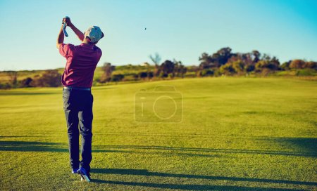 Téléchargez les photos : Le swing qui lui a valu son handicap. un jeune homme jouant au golf - en image libre de droit