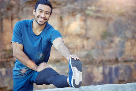 Photo for Portrait, sports and stretching with a man runner outdoor in the mountains for a cardio or endurance workout. Exercise, fitness and smile with a young male athlete getting ready for a run in nature. - Royalty Free Image