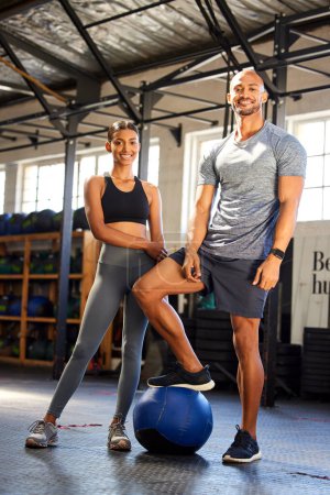 Photo for Fitness, gym and portrait of a man and woman with a medicine ball for training, workout or class. Couple of friends as client person and personal trainer at a health and wellness club for exercise. - Royalty Free Image