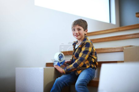 Photo for He didnt know packing would be so much fun. an adorable little boy packing boxes on moving day - Royalty Free Image
