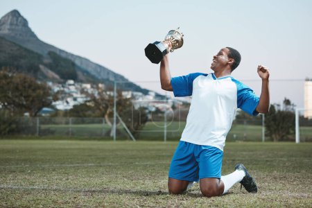 Photo for Soccer player, sports and man celebrate trophy on field for competition game outdoor. Black male athlete champion excited for football prize, award and win or sport achievement and success on a pitch. - Royalty Free Image