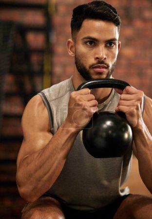 Photo for Weightlifting, training and man with kettle bell in gym for exercise, bodybuilder and fitness workout. Sports, muscle and serious male person squat with weight for wellness, healthy body and strength. - Royalty Free Image
