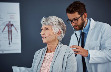 Photo for Time for her routine checkup. a doctor examining a senior patient with a stethoscope in a clinic - Royalty Free Image