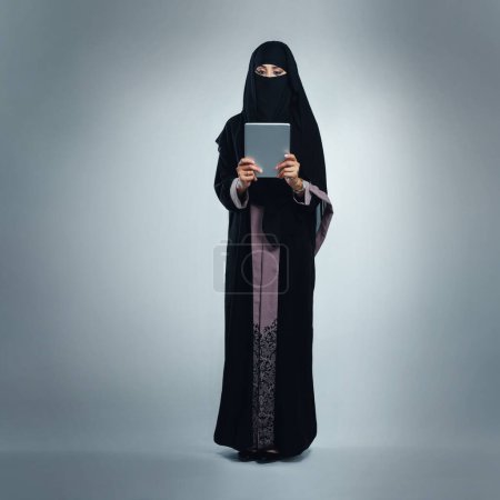 Foto de Debe tener tecnología moderna para una empresaria moderna. Foto de estudio de una mujer joven con una burka y una tableta digital sobre un fondo gris - Imagen libre de derechos
