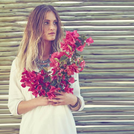 Téléchargez les photos : Faire une déclaration de mode avec des fleurs. une jolie jeune femme tenant un bouquet de fleurs fraîches - en image libre de droit
