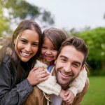 Family, piggy back and park portrait with a mom, dad and girl together with happiness and smile. Outdoor, face and summer vacation of a mother, father and kid with bonding, parent love and child care.