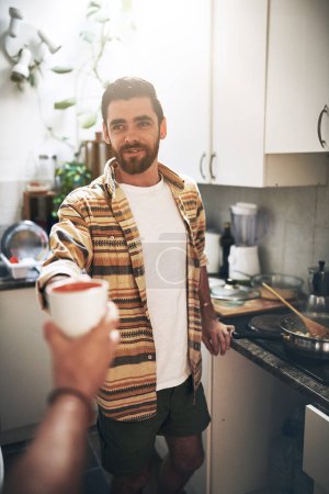 Foto de Esto es para ti. POV toma de un hombre irreconocible recibiendo una taza de café dentro de la cocina durante el día - Imagen libre de derechos