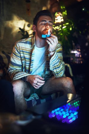 Photo for Time to get high. a handsome young man lighting up a joint of cannabis at home - Royalty Free Image