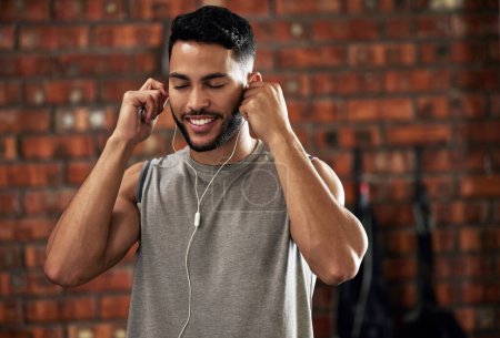 Photo for Fitness, earphones and music, man in gym listening to streaming service for motivation podcast and smile. Exercise, workout and happy bodybuilder, online radio or audio for healthy mindset in club - Royalty Free Image