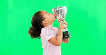 Photo for Celebration, win and face of child with trophy isolated on a green screen studio background. Excited, success and portrait of a girl kissing an award for sports, achievement and champion with mockup. - Royalty Free Image