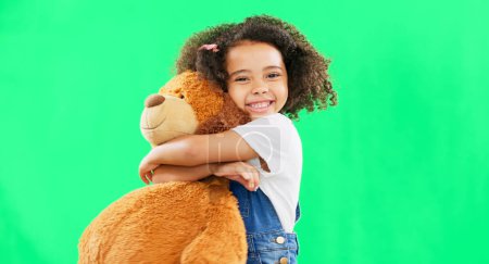 Photo for Happy, little girl and hugging teddy bear on green screen of cute innocent child isolated against studio background. Portrait of adorable kid smile with soft toy hug for childhood on chromakey mockup. - Royalty Free Image