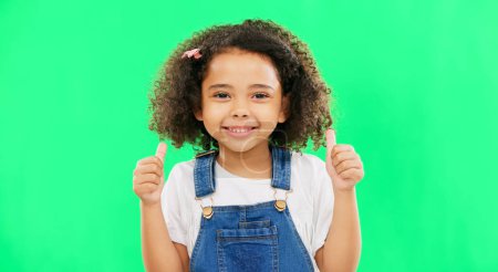 Photo for Cute, green screen and face of a child with a thumbs up isolated on a studio background. Winning, success and portrait of a girl kid with an emoji hand gesture for motivation, yes and agreement. - Royalty Free Image