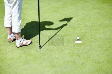 Photo for Flag, shoes or person playing golf for fitness, workout or exercise with ball shadow on a green course. Legs of golfer, golfing or feet of athlete training or exercising in a sports game or practice. - Royalty Free Image