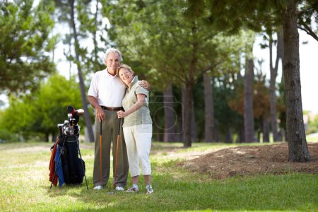 Téléchargez les photos : Portrait, sourire ou heureux vieux couple sur le terrain de golf en séance d'entraînement de remise en forme, l'exercice ou rond ensemble sur l'herbe. Embrasser, homme âgé en bonne santé étreignant ou souriant dans le jeu de sport de golf avec la femme âgée. - en image libre de droit
