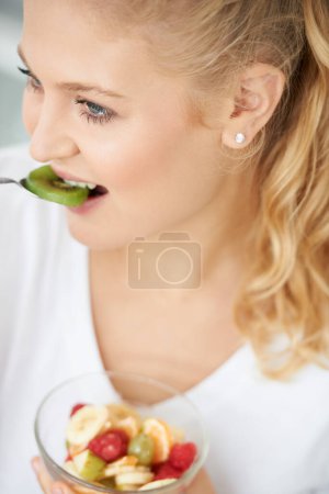 Photo for Kiwi, eating or happy woman with fruit salad, morning breakfast meal or lunch diet in home kitchen. Smile, gut health or vegan girl with fruits, vitamin c or food bowl to lose weight for wellness. - Royalty Free Image