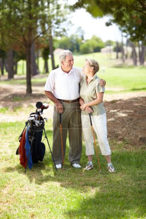 Téléchargez les photos : Heureux vieux couple, amour ou golfeurs sur le terrain en séance d'entraînement de remise en forme, l'exercice ou rond ensemble sur le terrain d'herbe. Embrasser, homme âgé en bonne santé étreignant ou souriant dans le jeu de sport de golf avec la femme âgée. - en image libre de droit