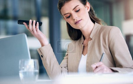 Photo for Business woman, writing and speaker phone for communication, planning or strategy at the office. Female person or employee in project management with mobile smartphone app or voice note at workplace. - Royalty Free Image